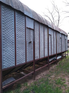 The side of a grey corn crib.